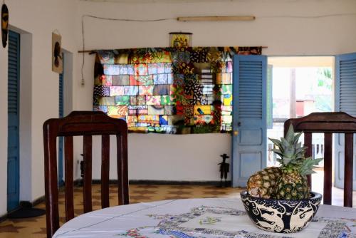 un ananas seduto su un tavolo con due sedie di Chambres d'hôtes - Chez Mama Sêdjro a Porto-Novo