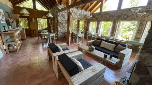 una sala de estar con sofás y mesas en un edificio en Hostería Brisas del Cerro en Villa La Angostura