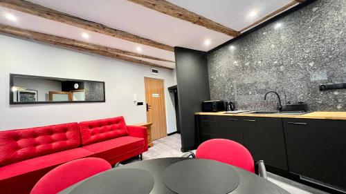 ein Wohnzimmer mit einem roten Sofa und einem Tisch in der Unterkunft Apartamenty Katowicka 38 in Świętochłowice