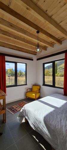 a bedroom with a bed and two windows and a couch at Racha Cornfield House in Oni