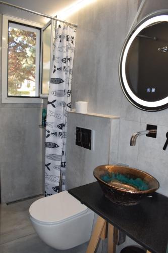 a bathroom with a sink and a toilet and a mirror at 3h Chris Μικρό, φωτεινό & βολικό σπίτι in Athens