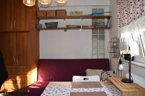 sala de estar con sofá rojo y mesa en 3h Chris Μικρό, φωτεινό & βολικό σπίτι, en Atenas