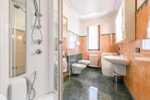 a bathroom with two toilets and a sink and a shower at Prestige Apartment in Sirmione