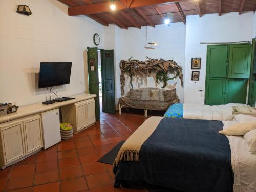 a bedroom with two beds and a flat screen tv at Casa Finca Paititi in San Antonio de Pereira