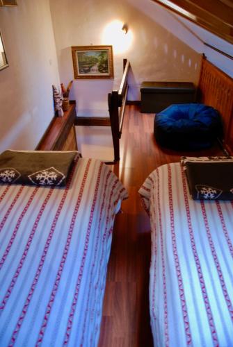 two beds are sitting in a room with a staircase at Maisonette in Nus
