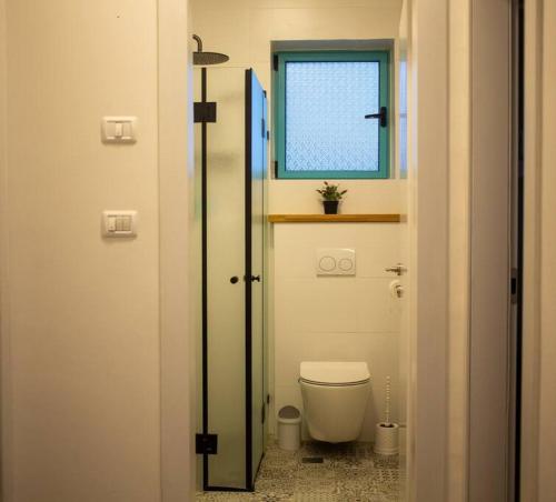 a small bathroom with a toilet and a window at family apartment Dead-sea view in Ovnat