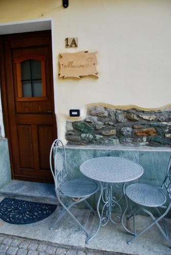 a table and two chairs in front of a building at Maisonette in Nus