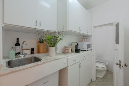 cocina blanca con lavabo y aseo en Typical Alfama Apartment, by TimeCooler en Lisboa