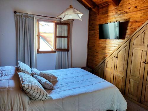 1 dormitorio con 1 cama y TV de pantalla plana en Cabaña Camalen en San Martín de los Andes