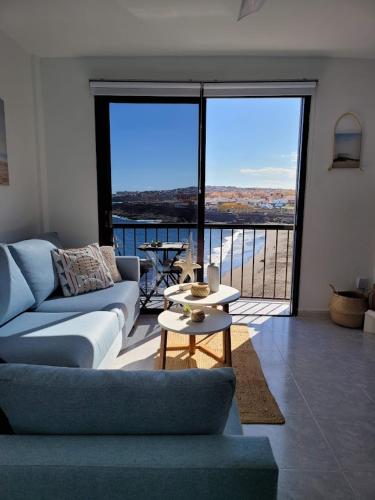 a living room with a couch and a large window at ALLINSEA LA GARITA in La Garita