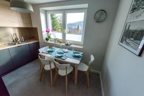 Apartament Wilaneska في كرينيتسا زدروي: مطبخ وغرفة طعام مع طاولة وكراسي