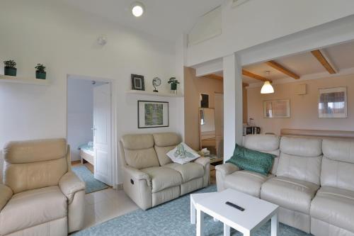 a living room with two couches and a table at AVIATOR Apartments & Rooms Nikola Tesla Airport Belgrade in Surčin