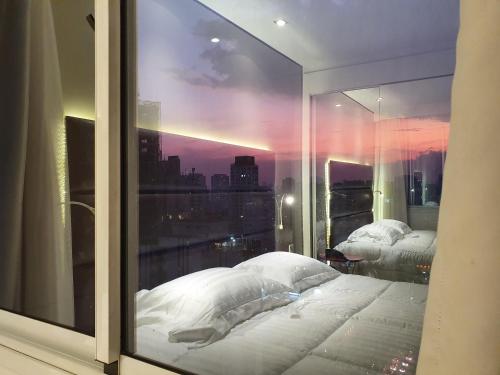 a bedroom with a window with a view of a city at Vila Olimpia Hotel in Sao Paulo