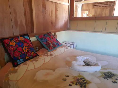 Finca Vista Hermosa - Room in Main House في Pluma Hidalgo: غرفة مع وسادتين على أرضية الغرفة