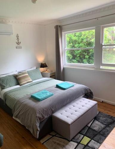 a bedroom with a large bed and a window at Relaxing cottage overlooking Crookhaven River in Greenwell Point