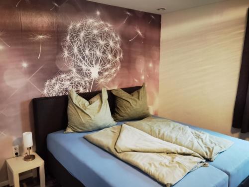 a bedroom with a bed with a dandelion painting on the wall at Modernes behagliches Haus mit Kamin, Terrasse und Garten in Magdeburg