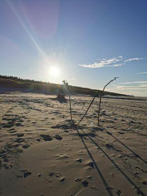 a kite on a beach with the sun in the background at Apartament w Choczewie in Choczewo