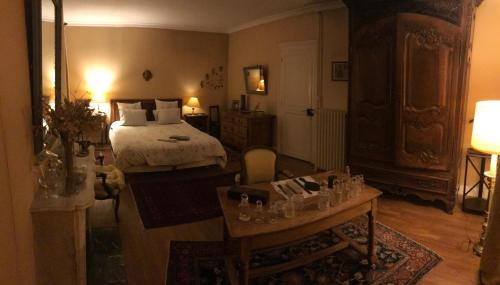 a bedroom with a bed and a table with glasses on it at La passerelle in Combleux