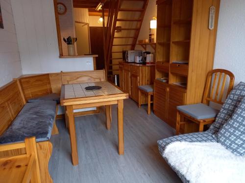 Cette chambre comprend une table, un canapé, une table et des chaises. dans l'établissement Appartement Mont Dore tout confort, 2 pièces, 4 personnes, à Le Mont-Dore