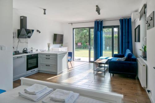 eine Küche und ein Wohnzimmer mit einem blauen Sofa in der Unterkunft Apartamenty Zielona Lipka in Pisz