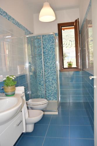 a blue bathroom with two toilets and a shower at Villa delle Stelle in Scopello