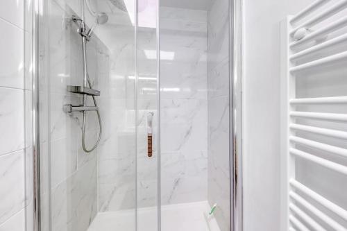 a bathroom with a shower with a glass door at Le cosy in Saint-Cyr-lʼÉcole
