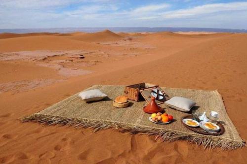 a table in the desert with food on it at Mhamid Tours in Mhamid