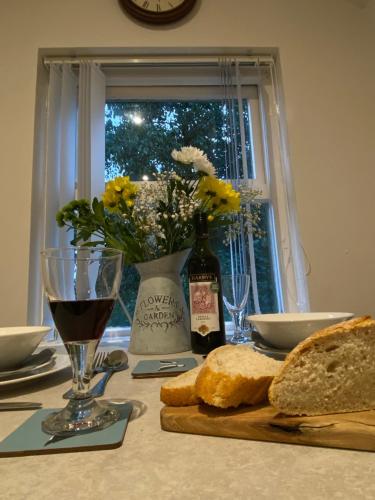 a table with bread and a glass of wine and a window at Cosy Loft Apartment in Ballycastle