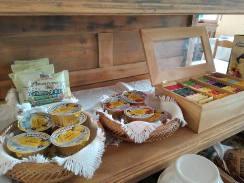 a table topped with baskets of food next to a box at Hotel Garnì Miramonti in Falcade
