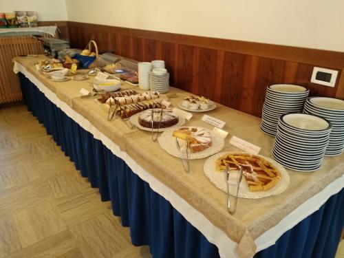 a long table with plates of food on it at Hotel Garnì Miramonti in Falcade