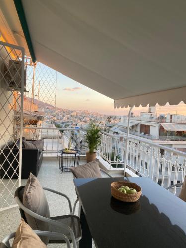 einen Balkon mit einem Tisch und Stadtblick in der Unterkunft Kolonaki 1 bedroom and 1 Sofabed Amazing Penthouse flat in Athen