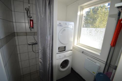 baño con lavadora y ventana en Högsnäsgården en Överhörnäs