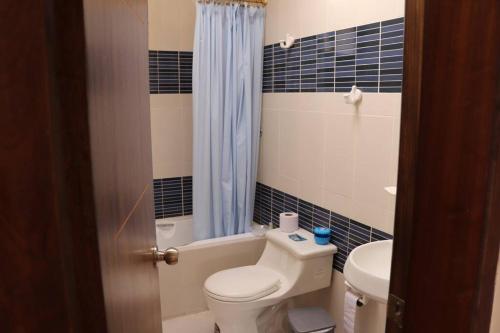 a bathroom with a toilet and a tub and a sink at Cozy and Spacious Home with Incredible Location in Cuenca