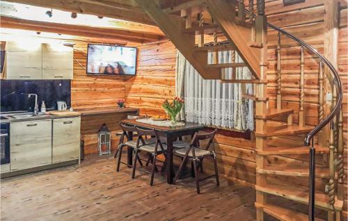 a kitchen and dining room with a table in a log cabin at Awesome Home In Osiek With Kitchenette in Osiek