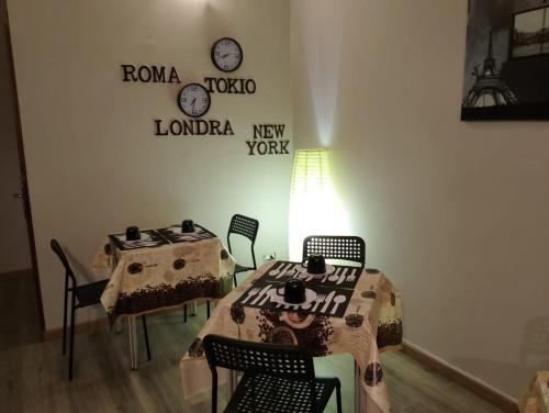 a room with a table and chairs and clocks on the wall at HOTEL Via Emilia Ovest 224 SELF CHECK-IN in Parma