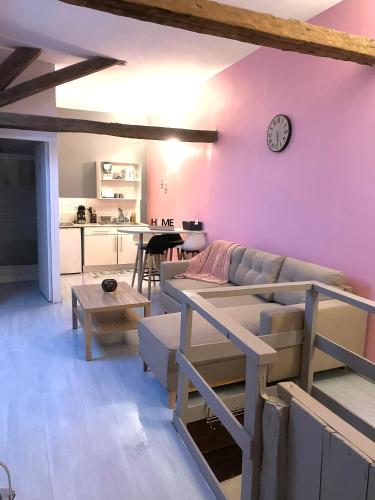 - un salon avec un canapé et une horloge murale dans l'établissement Chablis: grand studio en plein centre ville, à Chablis