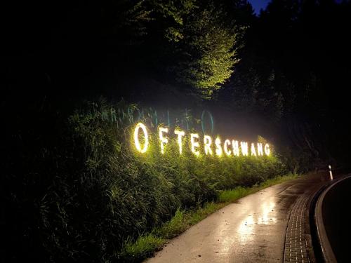 a lit up sign on a road at night at Ferienwerk in Ofterschwang