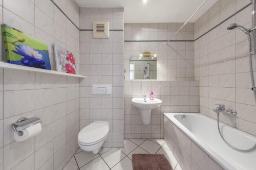 a bathroom with a toilet and a sink and a tub at Schoenes Studio im Zentrum in Berlin