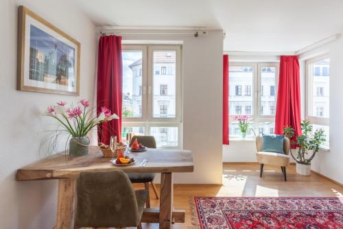 a dining room with red curtains and a table and chairs at Stilvolles Studio in downtown Mitte, Boxspringbett, Balkon, Blick über Berlin auf den Himmel, zentrale Lage, Kiez vor der Haustür in Berlin