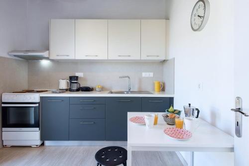 a kitchen with white cabinets and a white table at Tati Apartment in Kassiopi