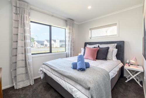 a bedroom with a bed with a blue teddy bear on it at Citron 9 in Greytown