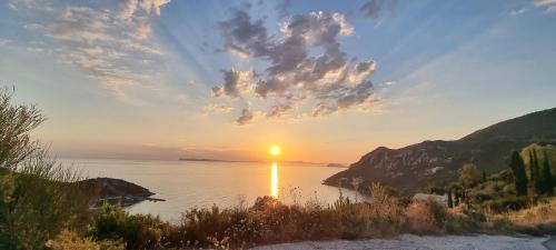 a sunset over a body of water at ΑRILLA STUDIOS in Perdika