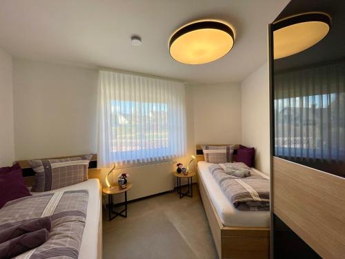 1 Schlafzimmer mit 2 Betten und 2 Fenstern in der Unterkunft Ferienwohnung Zeitlos in Attendorn
