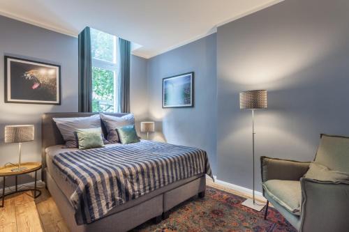 1 dormitorio con paredes azules, 1 cama y 1 silla en Paul Robeson Str. II, en Berlín