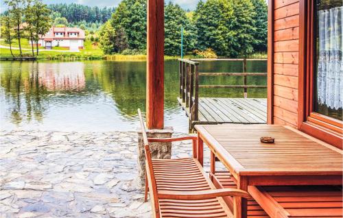 a porch with a table and chairs and a view of a lake at Beautiful Home In Stawiguda in Stawiguda