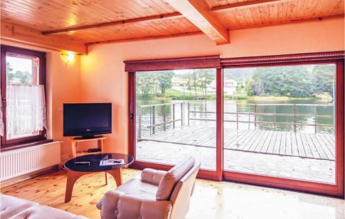 a living room with a television and a large window at Beautiful Home In Stawiguda in Stawiguda