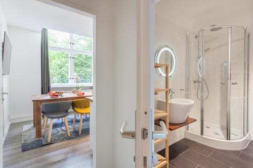 a bathroom with a table and a shower and a dining room at The Paul II - stylish & central 3 BR apartment, group & family friendly, 4- 6 Guests in Berlin