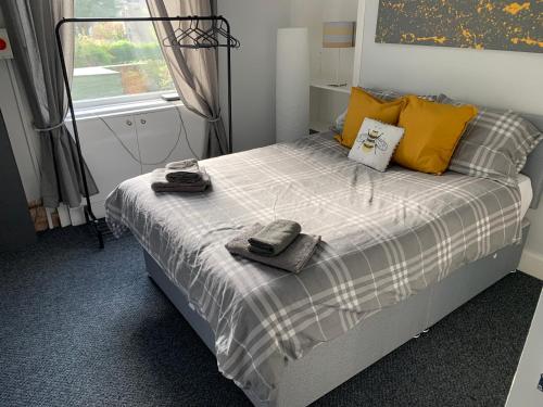 a bedroom with a bed with yellow pillows and a window at Nelson st (MAYBOLE) in Largs