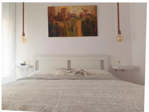 a bedroom with a bed with a painting on the wall at Apartamento MARIANA in Granada
