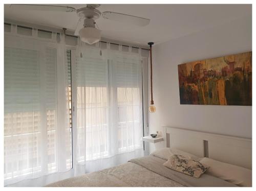 a bedroom with a bed and a large window at Apartamento MARIANA in Granada